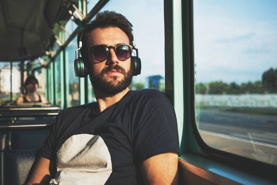 Young man riding in public transport listening to the music